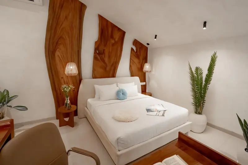 Une chambre lumineuse avec un grand lit et des éléments décoratifs en bois.