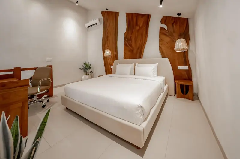 Une chambre lumineuse avec un grand lit et un bureau.