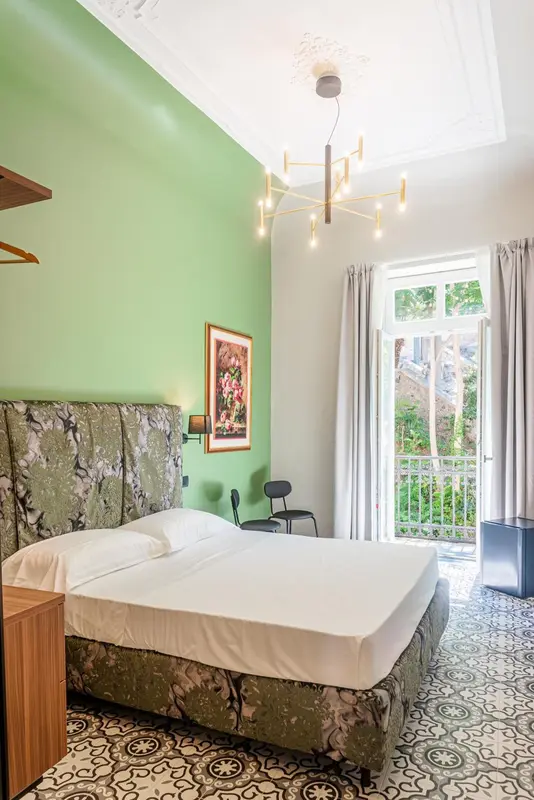 Une chambre lumineuse avec un grand lit et un accès à un balcon.