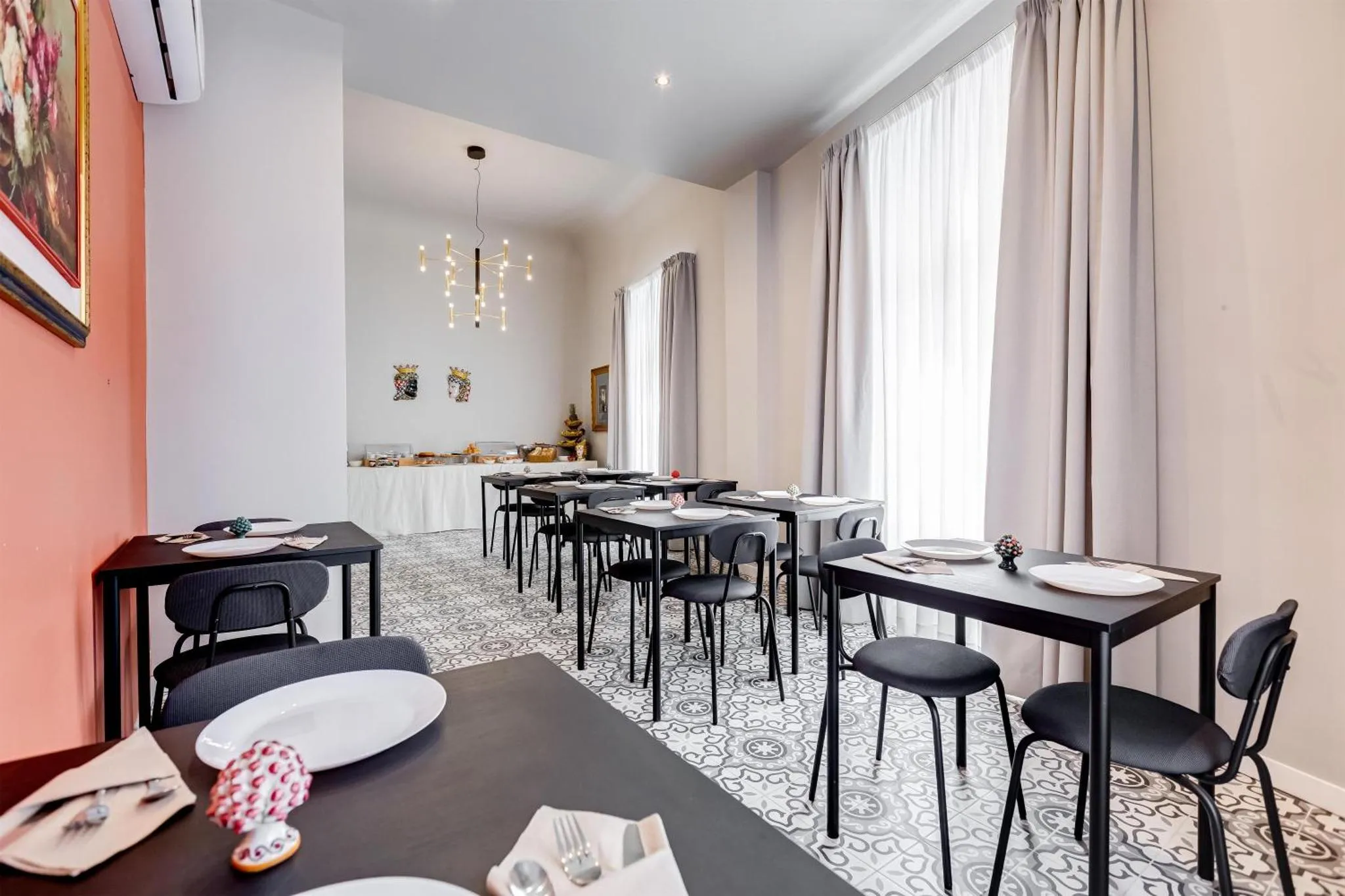 Une salle lumineuse avec des tables dressées pour un repas.