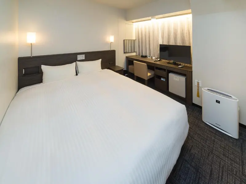 Une chambre d'hôtel moderne avec un lit double et un bureau.