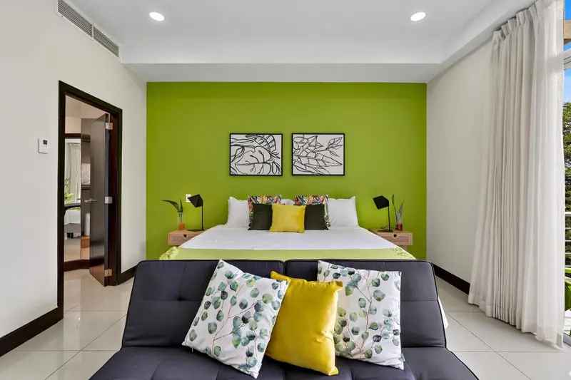 Une chambre lumineuse avec un grand lit et un canapé.