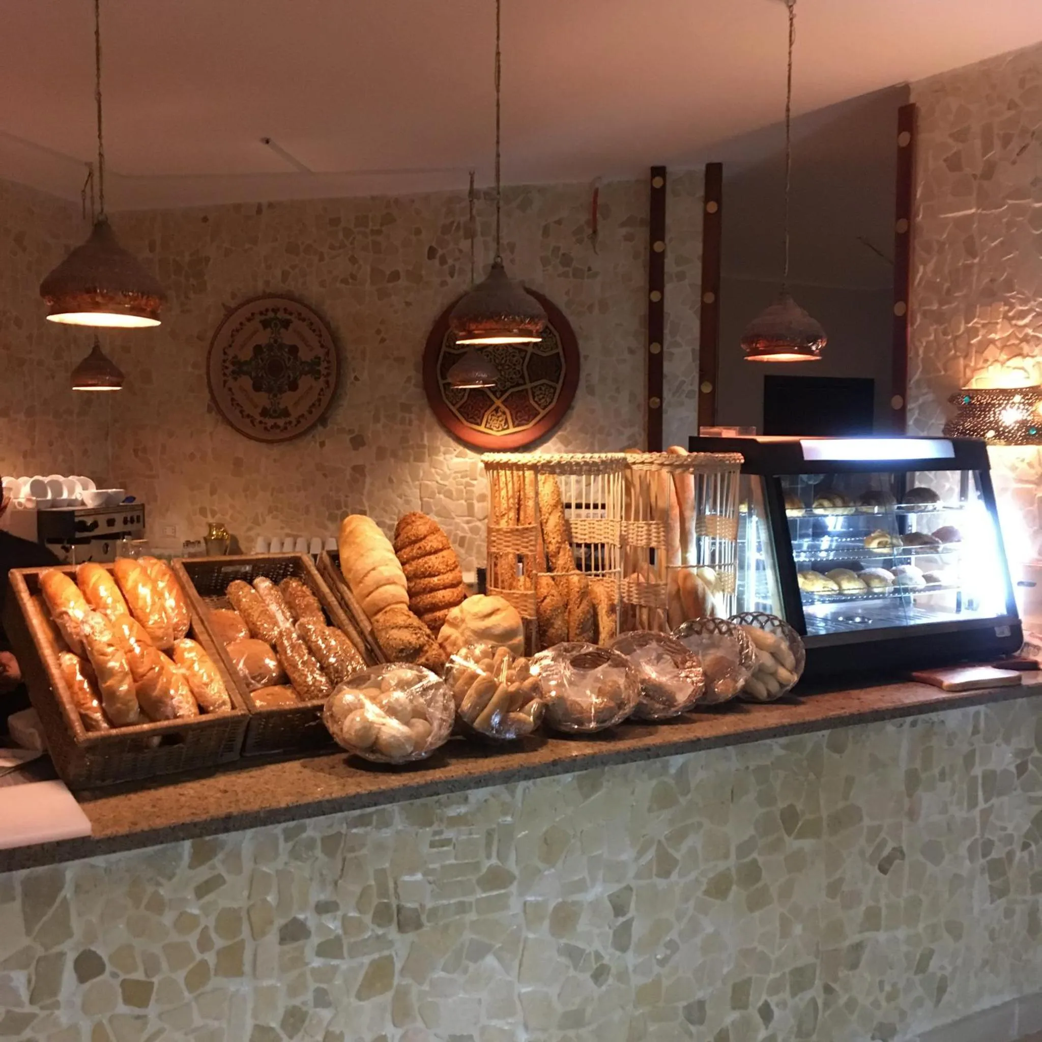 Un comptoir de boulangerie présente une variété de pains et de pâtisseries.
