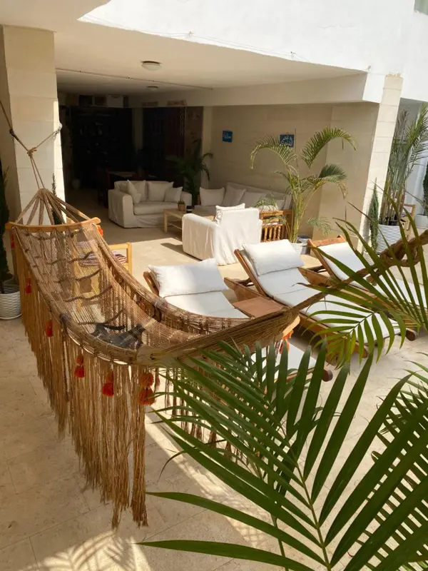 Espace de détente extérieur avec hamac et mobilier de jardin.