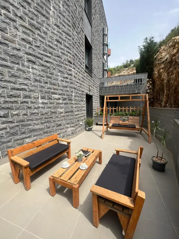 Terrasse aménagée avec mobilier en bois et plantes.