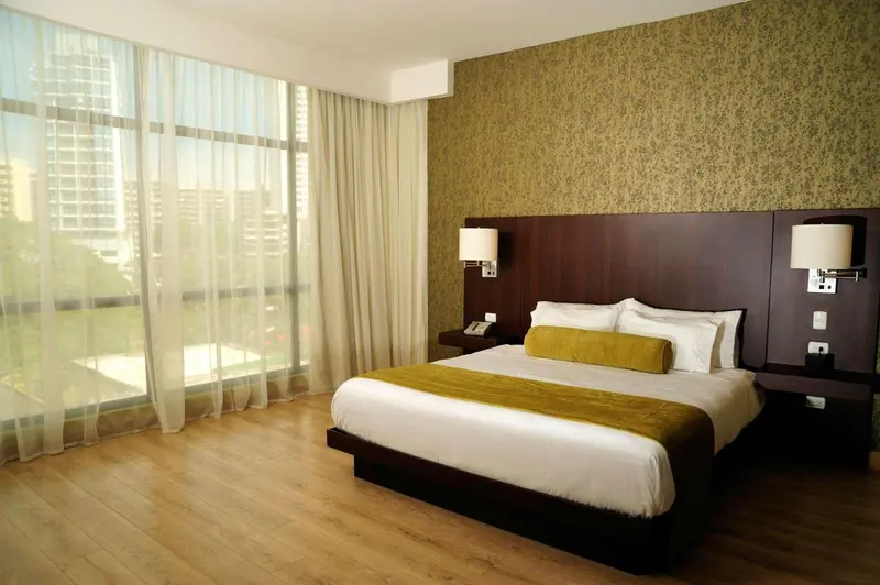 Une chambre d'hôtel lumineuse avec un grand lit et une vue sur la ville.