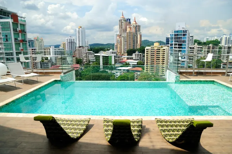 Une piscine à débordement offre une vue sur la ville et la végétation environnante.