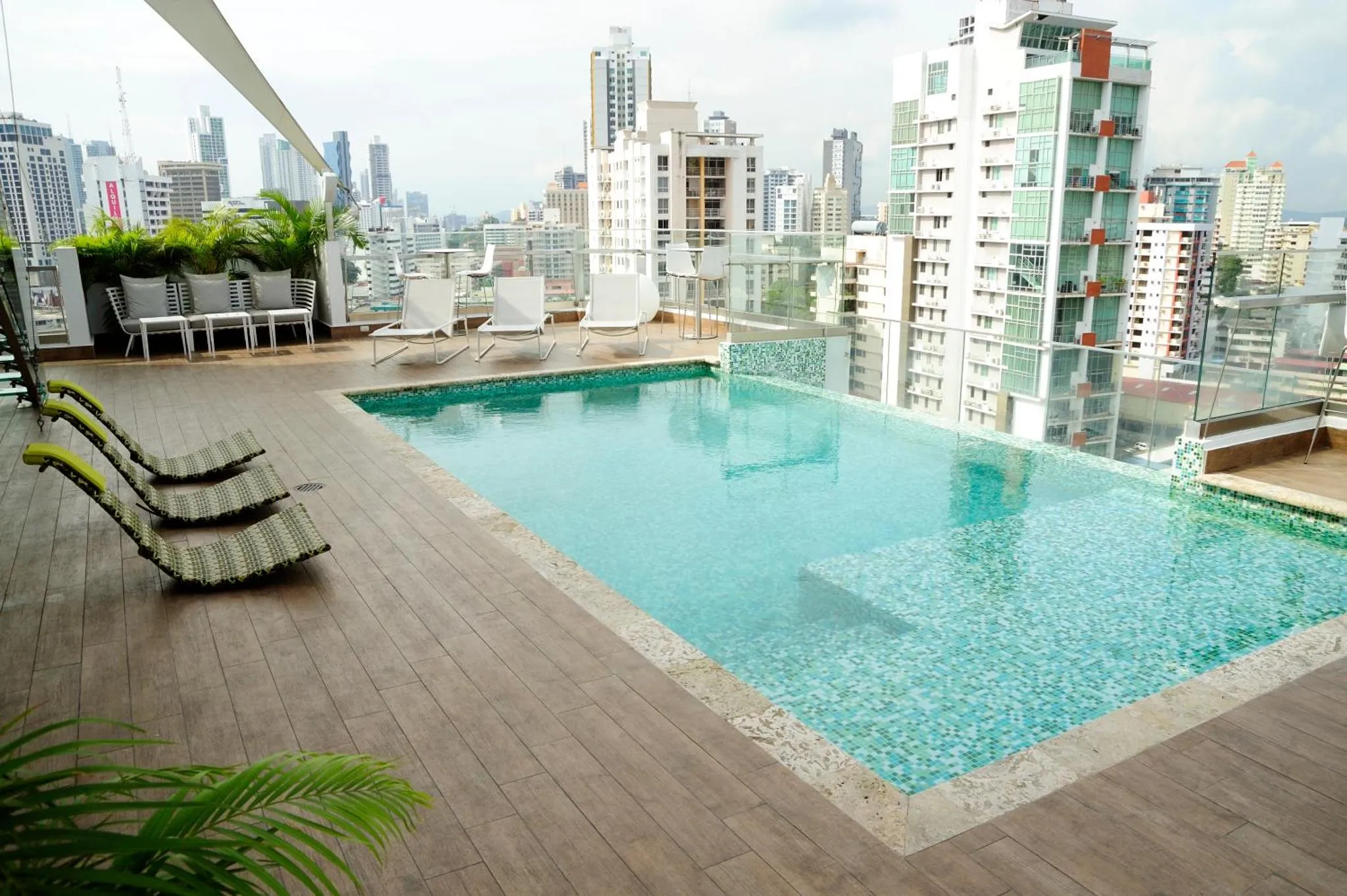 Terrasse avec piscine et mobilier de détente.