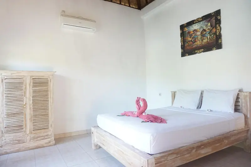 Une chambre lumineuse avec un lit décoré de serviettes en forme de cygnes.
