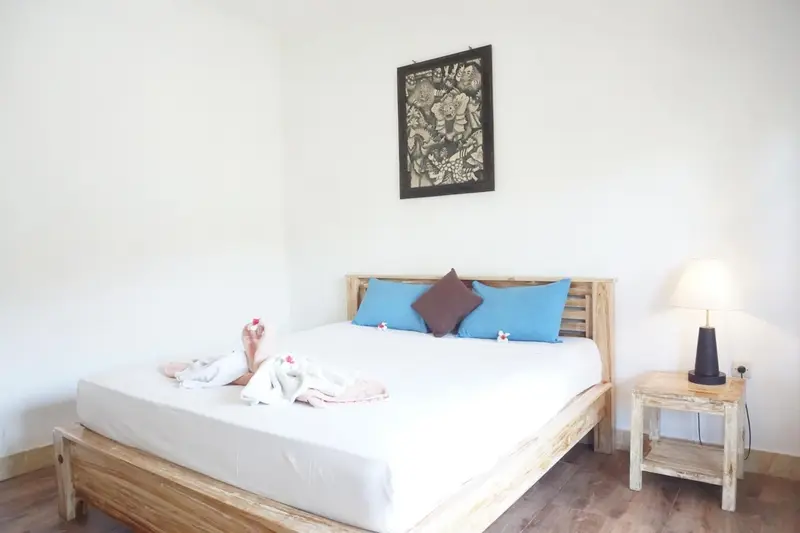 Une chambre lumineuse avec un lit décoré de coussins et de fleurs.