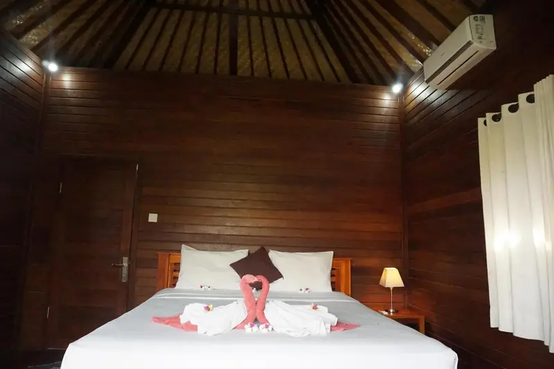 Une chambre avec un lit double décoré de serviettes en forme de cygnes.