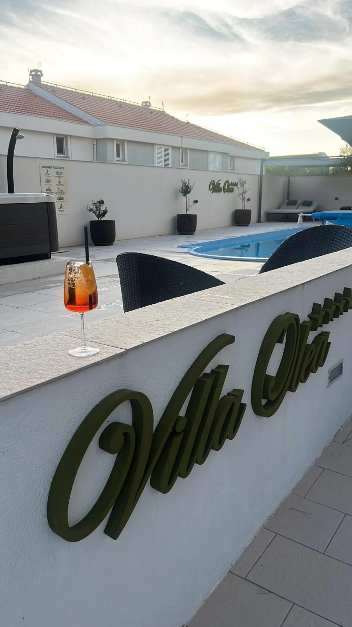 Une piscine avec un cocktail sur une terrasse ensoleillée.