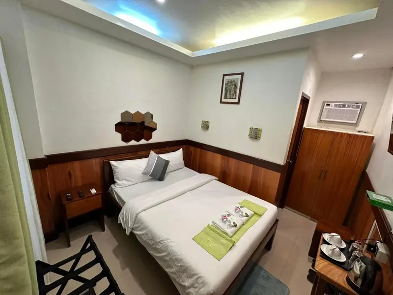 Une chambre lumineuse avec un lit simple et des meubles en bois.