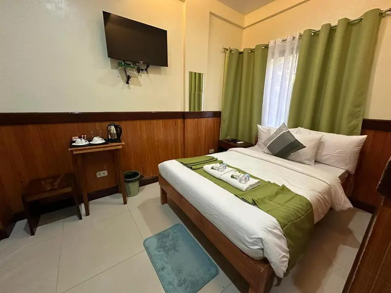 Une chambre lumineuse avec un lit double et une fenêtre.