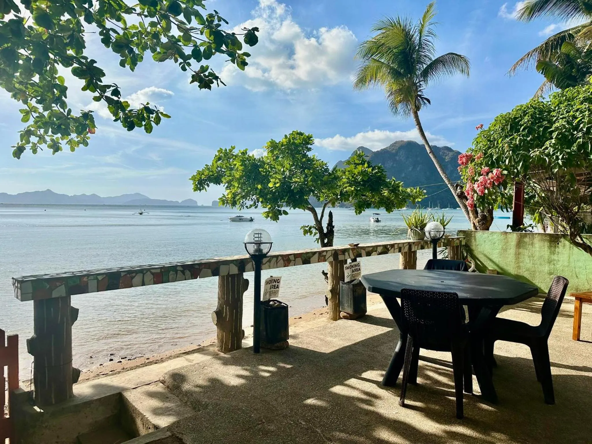 Terrasse avec table et chaises face à la mer.
