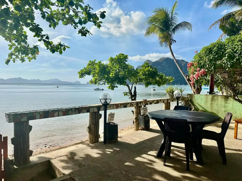 Terrasse avec table et chaises face à la mer.