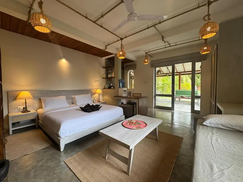 Une chambre lumineuse avec un lit blanc et une table basse en bois.