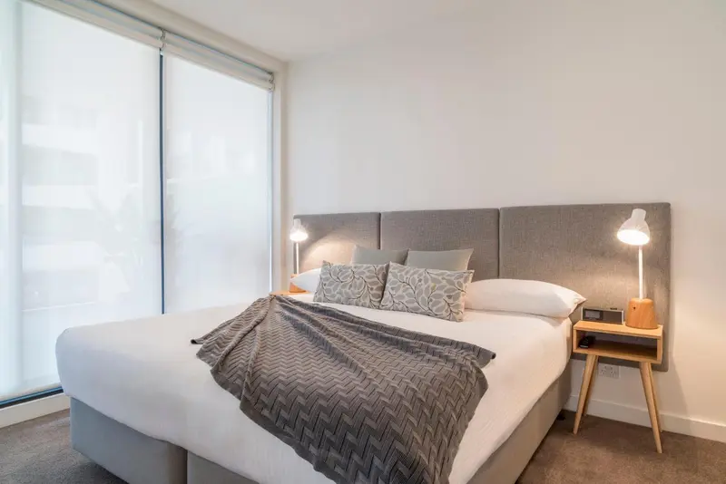 Une chambre lumineuse avec un grand lit et des tables de chevet.