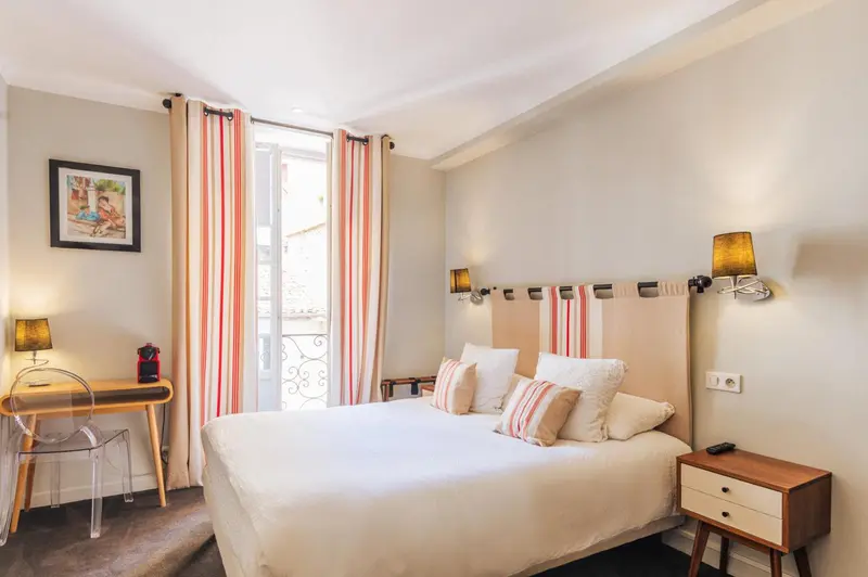 Une chambre lumineuse avec un lit double et un bureau.