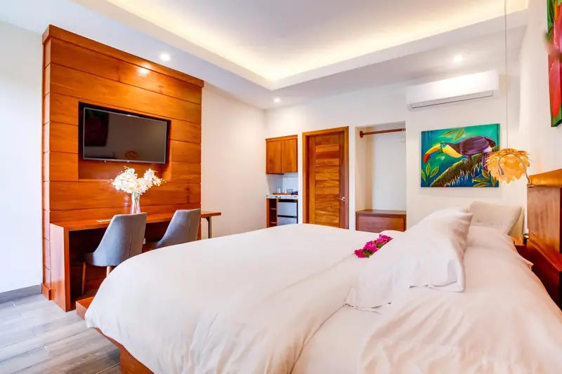 Une chambre lumineuse avec un grand lit et un espace bureau.