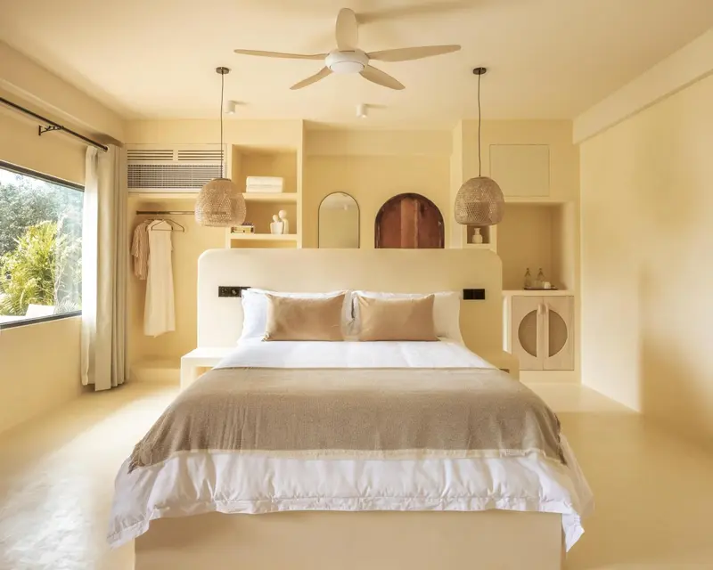 Une chambre lumineuse avec un grand lit et une décoration minimaliste.