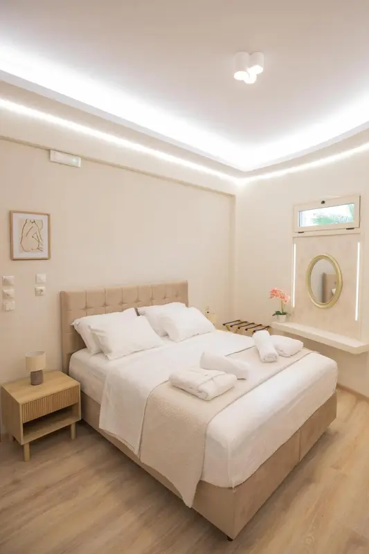 Une chambre lumineuse avec un grand lit recouvert de draps blancs.