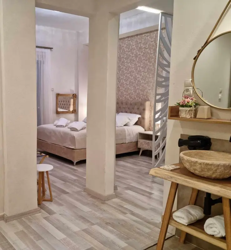 Une chambre lumineuse avec un lit et un lavabo en bois.