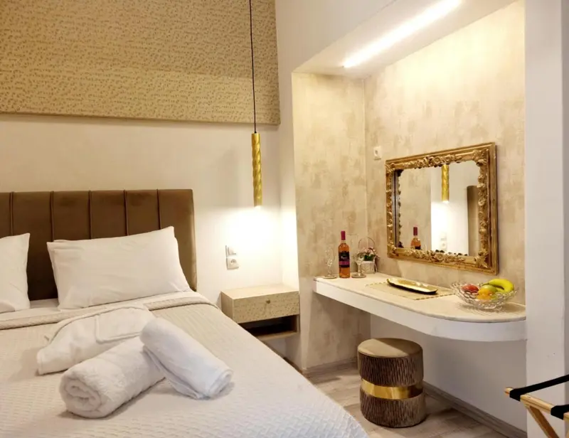 Une chambre lumineuse avec un grand lit et un coin coiffeuse.