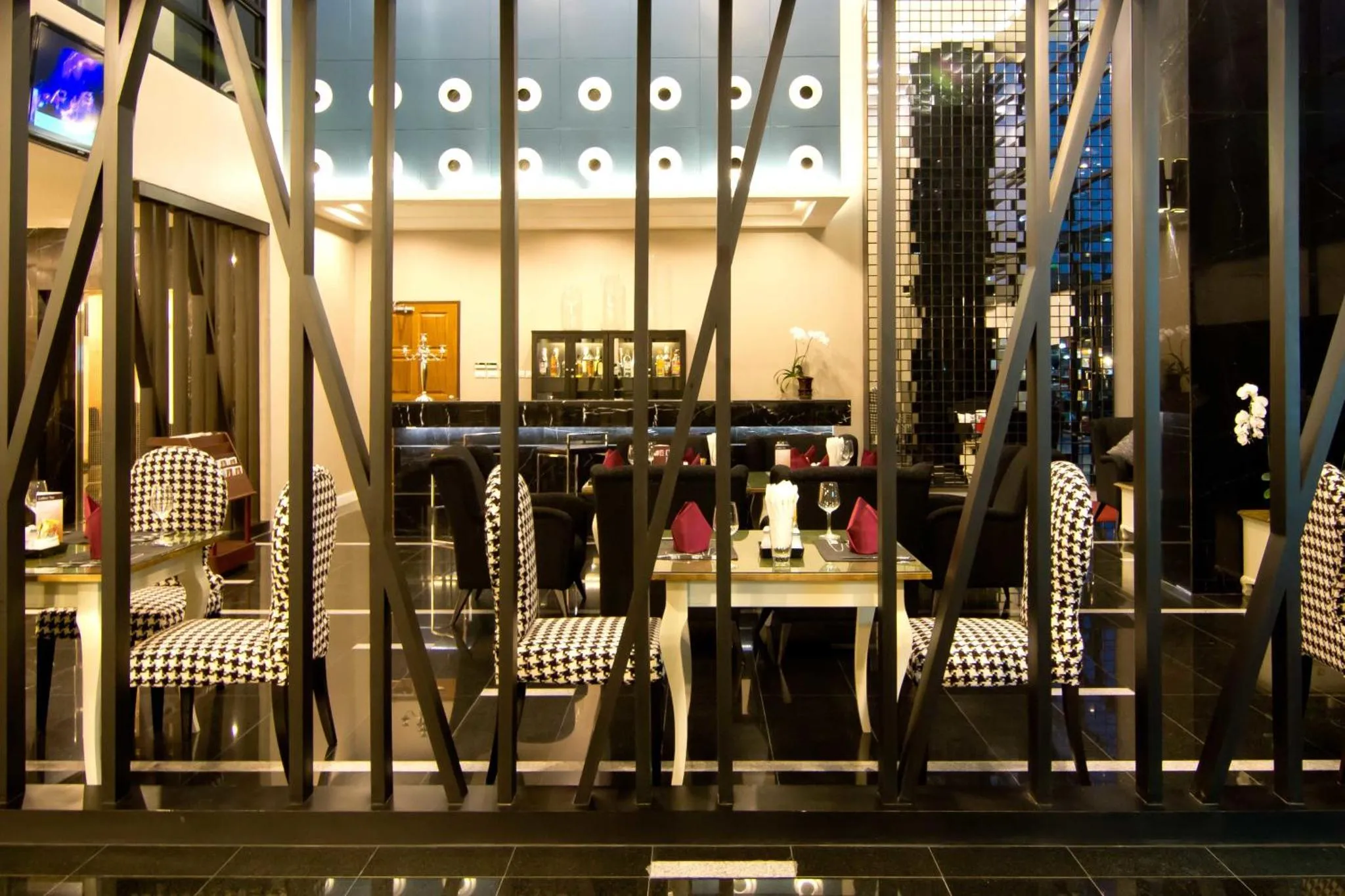 Une salle à manger moderne avec des tables dressées et des chaises à motifs.