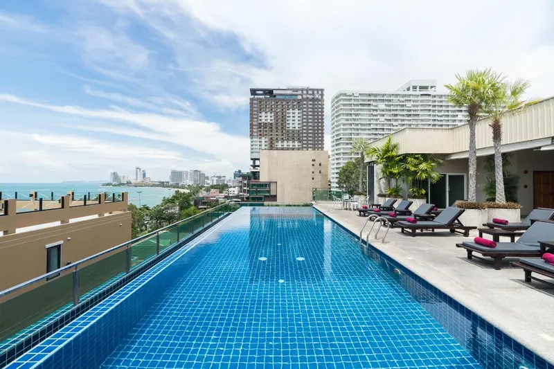 Une piscine rectangulaire à débordement offre une vue sur la mer et la ville.