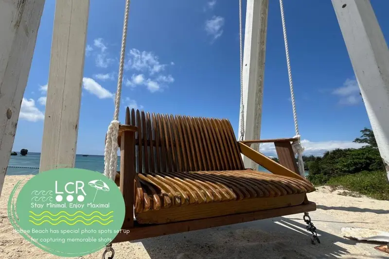 Balançoire en bois sur une plage ensoleillée avec vue sur la mer.