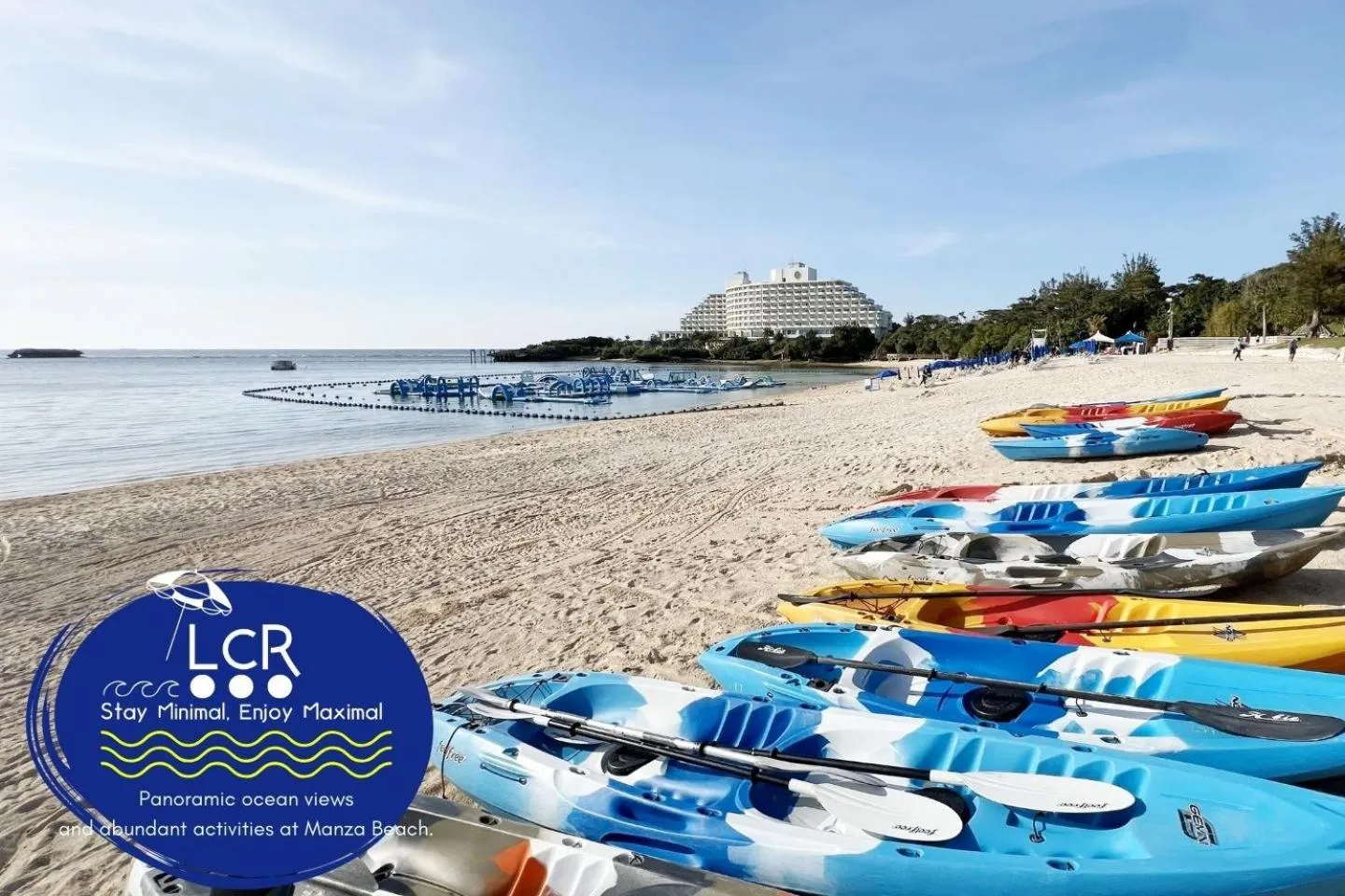 Des kayaks colorés sont alignés sur une plage de sable fin face à la mer.