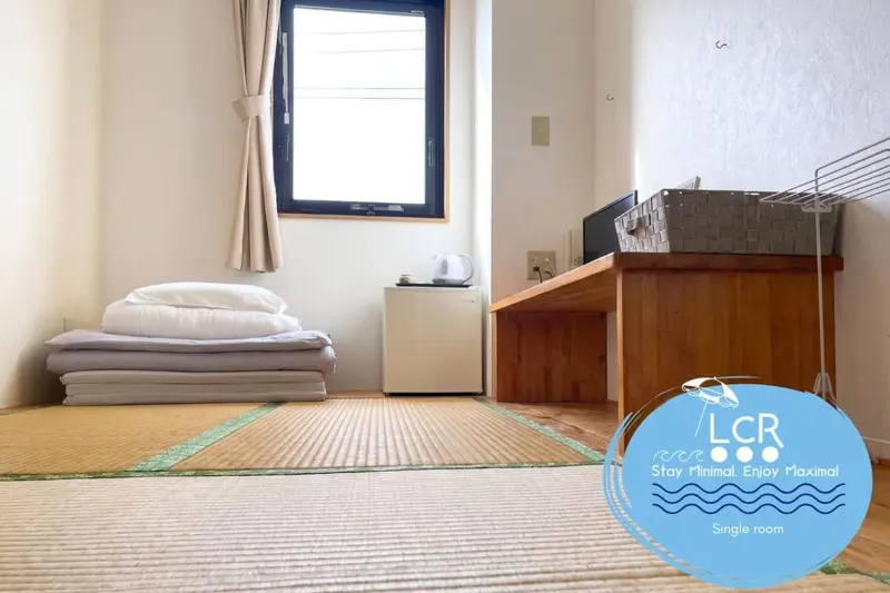 Une chambre simple avec un lit fait et une table basse en bois.