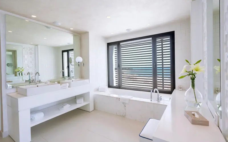 Une salle de bain lumineuse avec baignoire et double vasque.