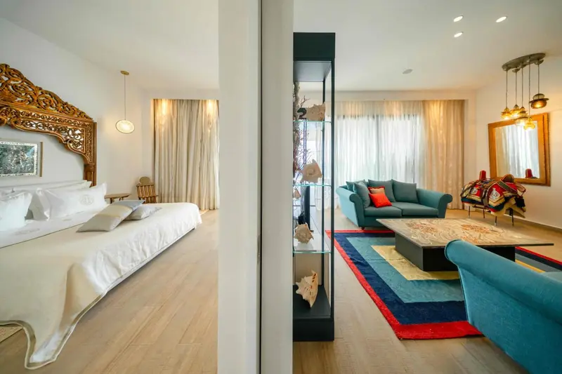 Une chambre lumineuse avec un lit et un espace salon.