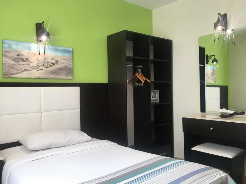 Une chambre avec un lit simple et un placard sombre.