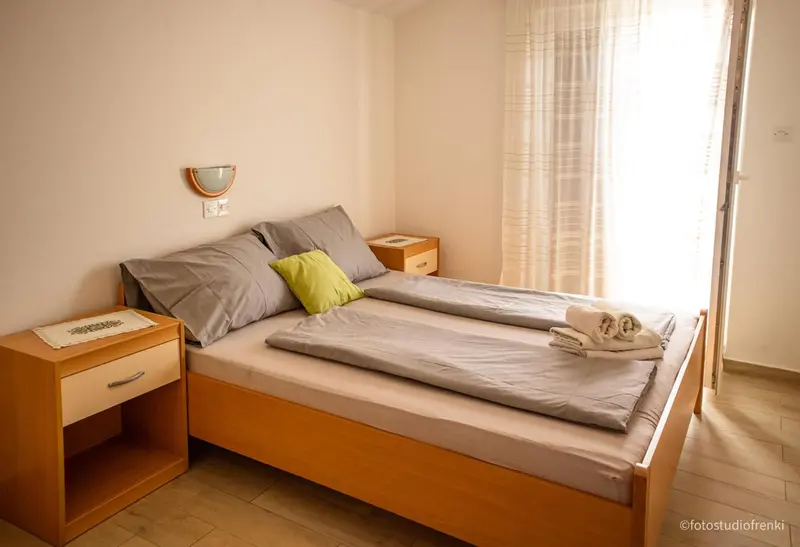 Une chambre lumineuse avec un lit fait et une table de chevet.