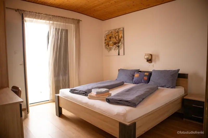 Une chambre lumineuse avec un lit double et un accès à une terrasse.