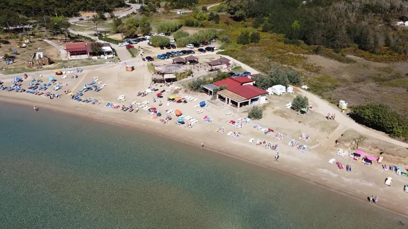 Vue aérienne d'une plage avec des transats et des parasols.