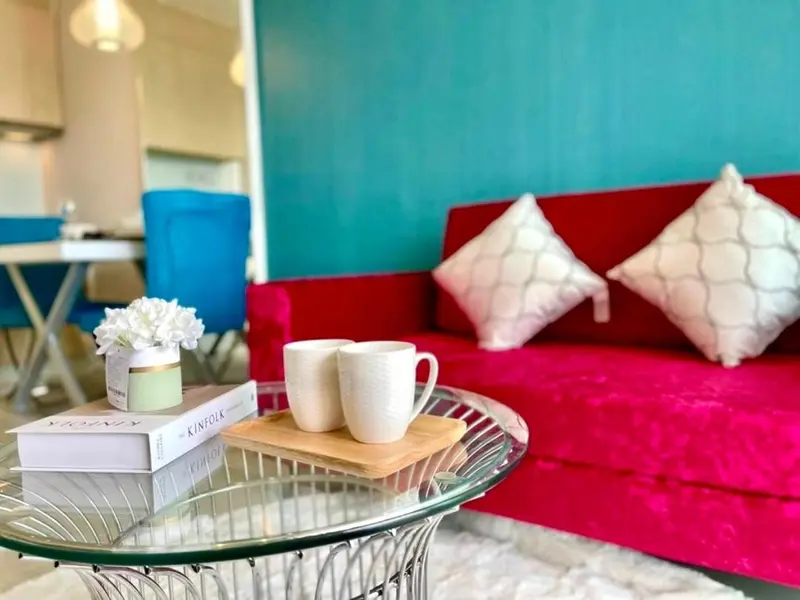Un salon moderne avec un canapé rouge et des coussins décoratifs.