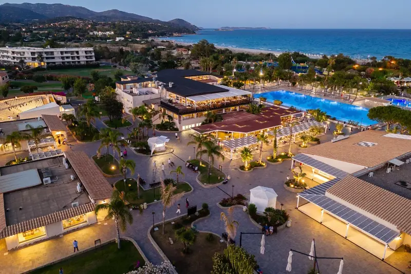Vue aérienne d'un complexe hôtelier avec piscine et végétation luxuriante.
