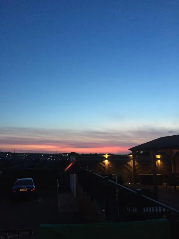 Ciel crépusculaire au-dessus d'une zone urbaine illuminée.