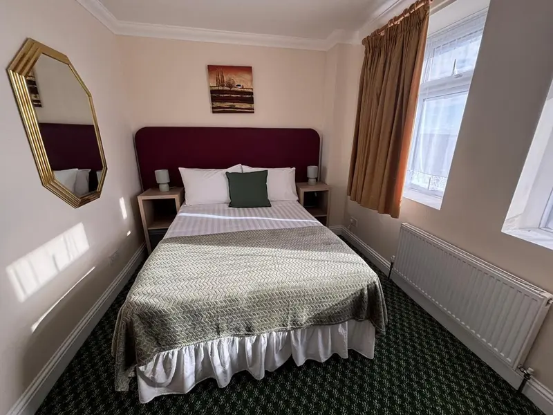 Une chambre avec un lit double et une fenêtre.