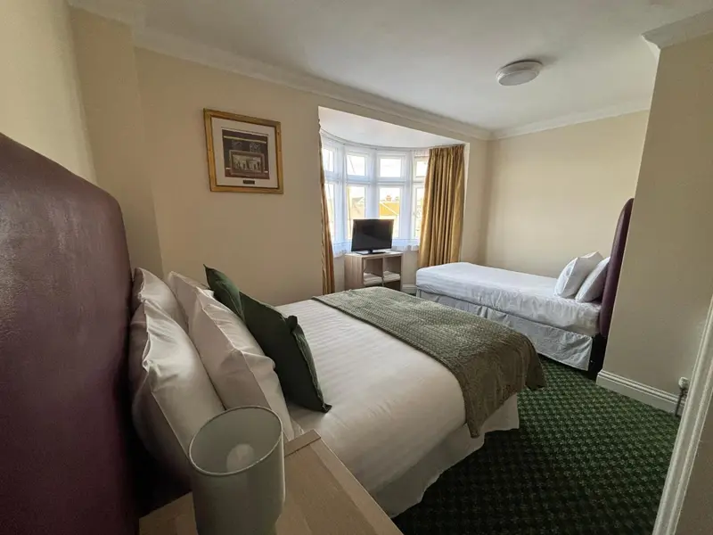 Une chambre avec deux lits simples et une fenêtre.
