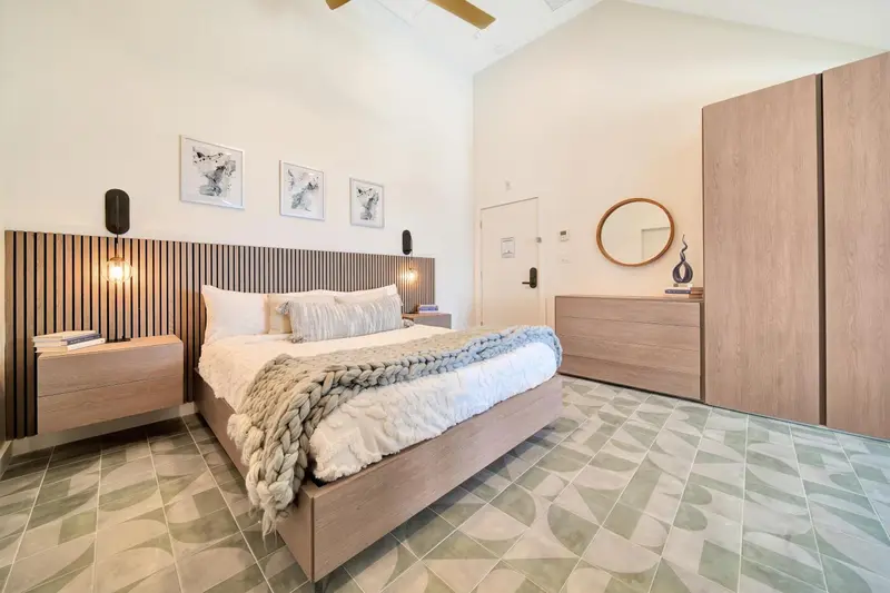 Une chambre lumineuse avec un grand lit et une décoration moderne.