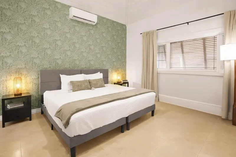 Une chambre lumineuse avec un grand lit et une fenêtre.