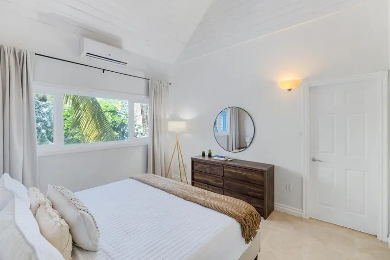 Une chambre lumineuse avec un lit recouvert d'une courtepointe et un bureau en bois.