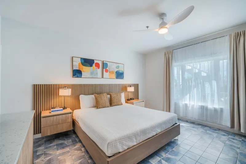 Une chambre lumineuse avec un grand lit et un accès à une terrasse.