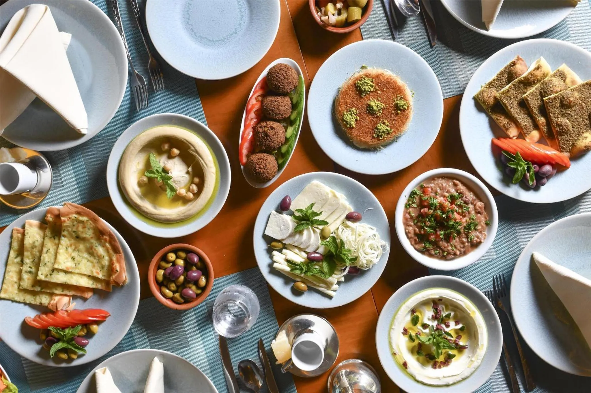 Une table dressée présente une variété de plats et de mezzés.