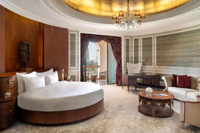 Une chambre spacieuse avec un grand lit rond et un bureau.